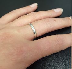 a woman's hand with a wedding ring on top of her finger and the other half of her left hand