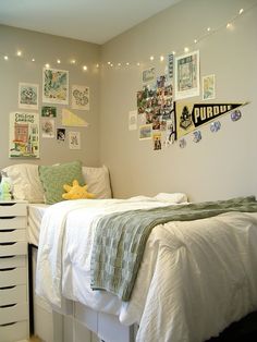 a bedroom with white walls and pictures on the wall