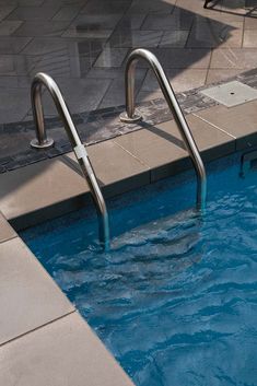 an empty swimming pool with steps leading up to the water's edge and tiled floor