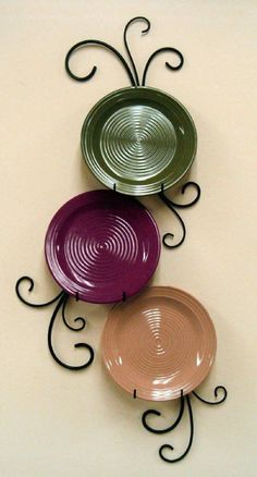 three plates are hanging on the wall with wrought iron designs and swirly rims