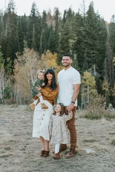 a family posing for a photo in the woods