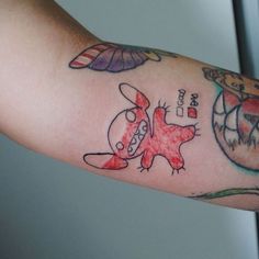 a person's arm with tattoos on it, including an image of a cartoon character