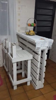 a kitchen table made out of pallet wood with two stools on each side