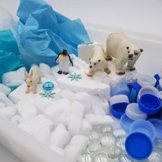 two polar bears are standing on an ice floet filled with water and plastic cups