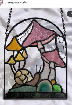 a stained glass lamp hanging from a chain on a white sheet with the words greenglass works above it