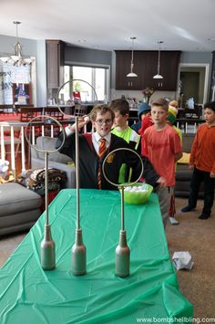 two young boys standing behind a green table with silver utensils on it in front of them