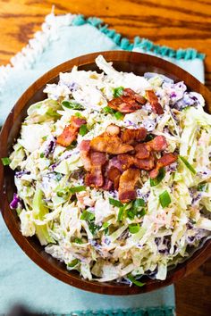 a wooden bowl filled with coleslaw and bacon