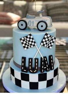 a blue cake with black and white checkered flags on it