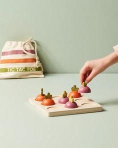 a person is picking up small vegetables from a cutting board