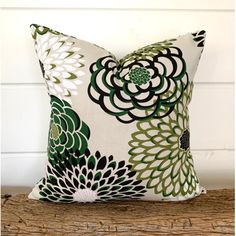 a green and white pillow sitting on top of a wooden table next to a wall