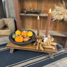 two candles and some pumpkins on a table