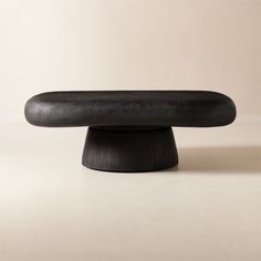 a black object sitting on top of a white table next to a beige wall and floor