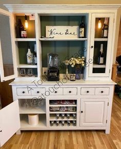 a white china cabinet with wine glasses and bottles