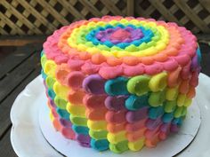 a multicolored cake sitting on top of a white plate