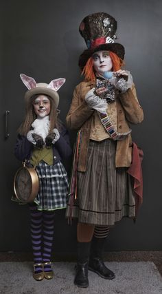 two clowns dressed in costumes standing next to each other with their faces painted like rabbits