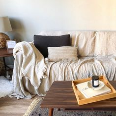 a living room with a couch, coffee table and rug on the floor in front of it