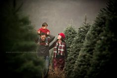 a man and woman walking through a christmas tree lot with their toddler on his shoulders