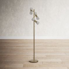 a floor lamp with four lights on it in an empty room next to a wall