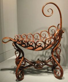 an ornate iron basket on display in a museum or home decor showroom with white walls and flooring