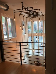 an empty room with lights hanging from the ceiling and wood flooring on the walls