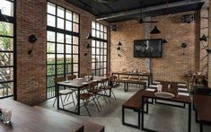 an empty restaurant with brick walls and tables set up for people to sit at them