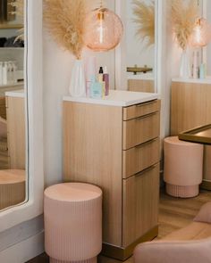 the interior of a hair salon with mirrors and stools in front of each room