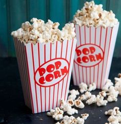 three buckets of popcorn sitting on top of a table