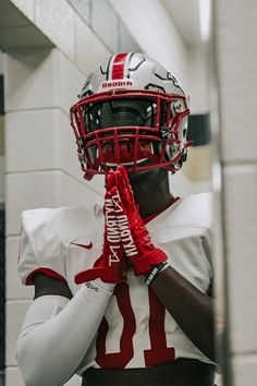 a football player wearing a helmet and holding his hands to his face while standing in front of a mirror