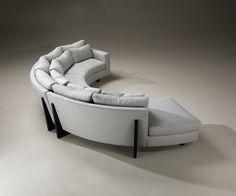 a white couch with pillows on it sitting next to a chair