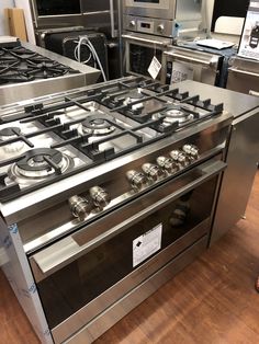 two ovens are on display in a kitchen with stainless steel cabinets and appliances behind them