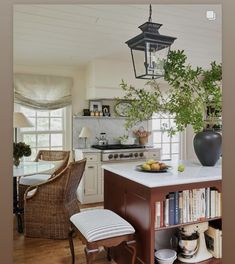 a kitchen with a table, chairs and a lamp hanging from the ceiling above it