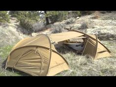 two tents sitting on top of a grass covered field