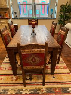 a dining room table with six chairs and a rug on the floor in front of it