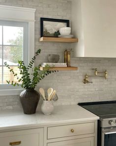 a kitchen with white counter tops and open shelving above the stove, along with an oven