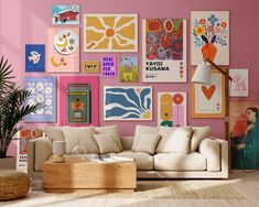 a living room with pink walls and lots of art on the wall, including posters