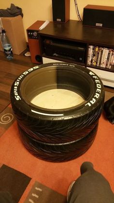 there is a dog laying on the floor next to a large tire shaped bed made out of tires