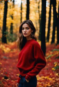 a woman standing in the woods with her hands on her hips and looking at the camera