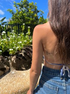 the back of a woman's body with flowers in the background