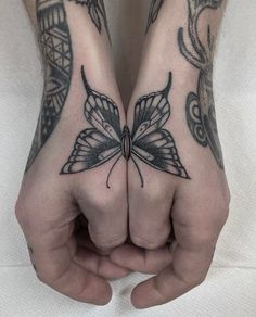 two hands with tattoos on them are holding each other's palms and their fingers