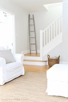 a living room filled with furniture and a stair case