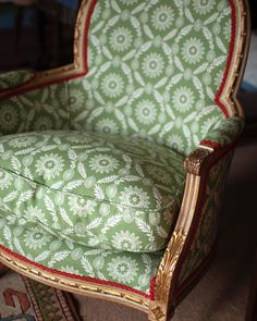 a green and white chair sitting on top of a carpeted floor next to a rug