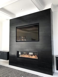 a modern fireplace in a living room with black and white decor