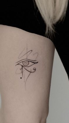 an eye tattoo on the back of a woman's thigh