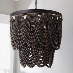 a chandelier made out of beads hanging from a ceiling in a living room