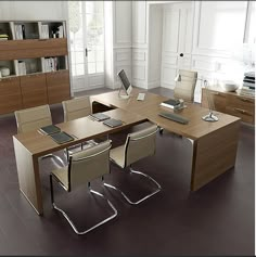 an office desk with chairs and a laptop on it