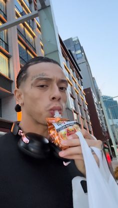 a young man is eating some food on the street