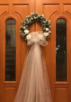 a wreath with tulle hanging on the front door