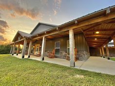 the front porch of a house with rocking chairs on it at sunset or sunrise time