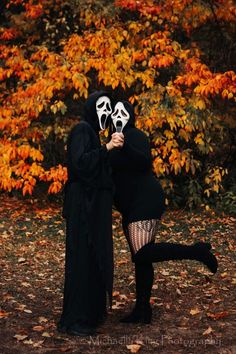 two people dressed up in costumes posing for the camera with their faces painted white and black