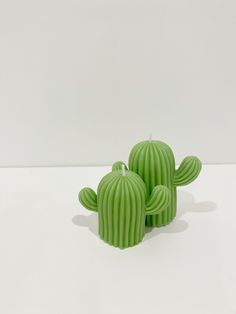 three green cactus candles sitting next to each other